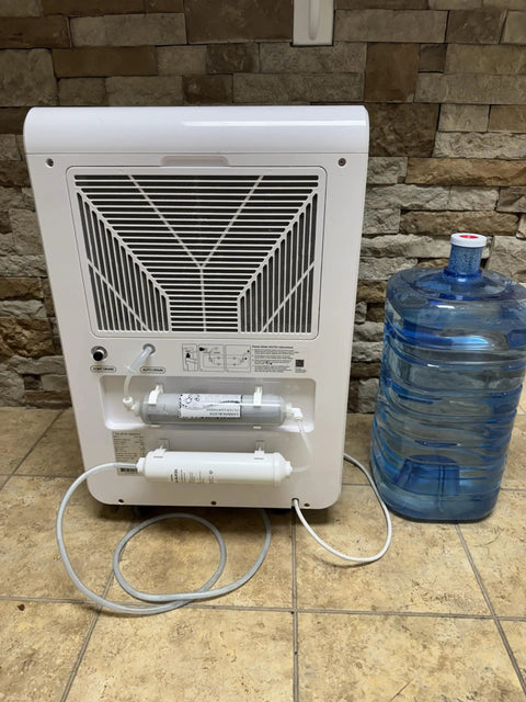 Back view of Fresh Drinking Water From Air Generating Up To 18 Gallons A Day With Multi Stage Filtration unit near bottle