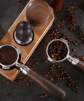 58mm Bottomless Portafilter Featuring Smooth Wood Ergonomic Handle And Double Shot Filter Basket For Breville Oracle Espresso Machines with ground coffee.