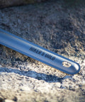 Ultralight Titanium Camping Spoon For Backpacking And Hiking, 16g Silver Utensil With 8.5 Inch Reach, resting on rock
