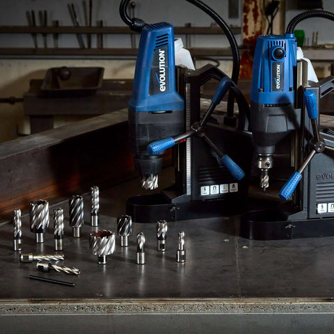 Front view of two blue Evolution mag drills with assorted annular cutters on a workbench