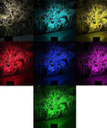 JUDYSSY Led Flood Lights Outdoor Solar Lights showcasing vibrant colors illuminating trees in a garden setting.