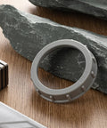 50 Pack 2 Inch Gray Plastic Conduit Bushings Heavy Duty Insulating Sleeves on wooden surface with tools and rocks.