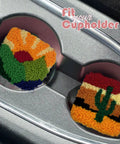 Two colorful punch needle coasters with landscape patterns in car cupholders. Easy To Use Punch Needle Coaster Kit For Beginners.