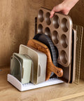 StoreMore Adjustable Bakeware Rack with steel wires and seven adjustable dividers organizing trays and sheets in a cabinet.