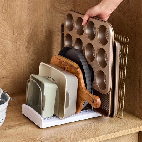 StoreMore Adjustable Bakeware Rack with steel wires and seven adjustable dividers organizing trays and sheets in a cabinet.