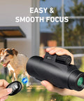 Image showing a hand holding 15x52 HD Monocular With Tripod For Hunting, Bird Watching, Hiking, And Travel, with Bluetooth camera remote.