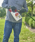Person holding Ready To Spray Outdoor Insect Killer With Hose End Sprayer For Lawn And Landscape, kills ants ticks mosquitoes
