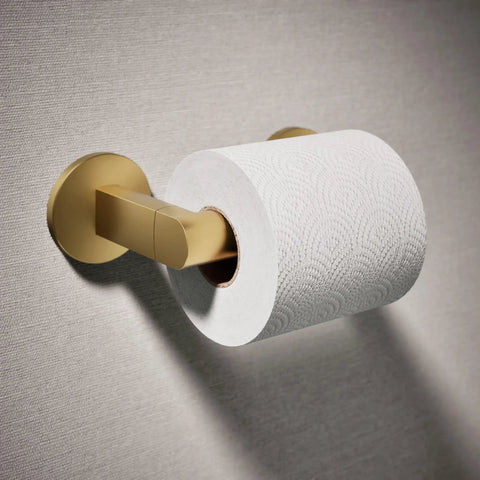 Components Pivoting Toilet Paper Holder With No Fuss Quick Change Design in brass, mounted with a roll, on a wall.