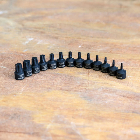 Stubby Torx Bit Socket Set 13 Piece With One Quarter Inch Drive Includes T7 Through T50 For Tight Spaces Ideal For Automotive Motorcycle And Electronic Fastener Removal displayed on wood