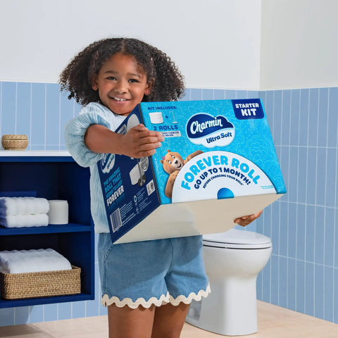 Child holding Ultra Soft Forever Roll Starter Kit with Brushed Stainless Steel Holder and Two Ply Forever Rolls in bathroom.