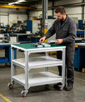 Solid Workhorse Three Tier Rolling Workbench With Anti Static Surface Heavy Duty Aluminum Frame is used in a workshop for organizing tools.