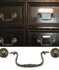 Set Of 6 Antique Bail Handle Drop Pulls With Screws In Vintage Bronze, shown on dark cabinet drawers, 3.3 inch centers