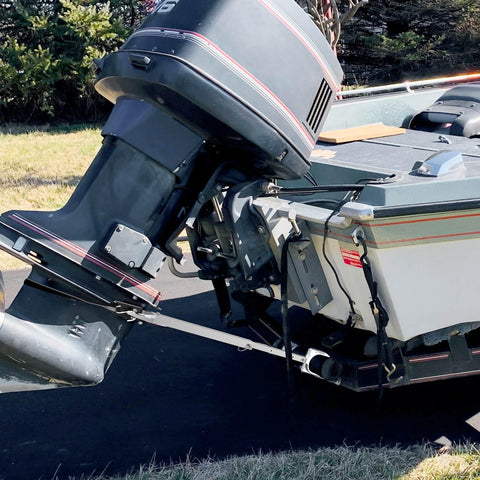 Side view of boat with Adjustable Transom Saver From 23 To 35 Inches For Boat Motor Support installed, showing engine stability on trailer.