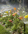 Pro 4-Inch Pop Up Sprinkler Head With Adjustable 0 To 360 Degree Spray Pattern watering a garden with colorful flowers