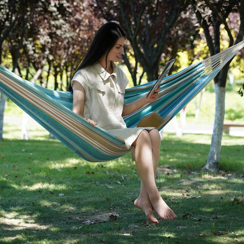 Woman relaxing in Easy Setup 1 To 2 Person Outdoor Hammock With Tree Straps And Carry Bag, Blue and Green, in a garden setting