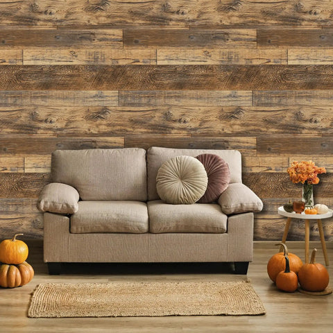 Living room with 17.71 In By 118 In Distressed Wood Plank Peel And Stick Wallpaper With Rustic Wood Grain Pattern, couch, and pumpkins.