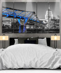 Modern bedroom featuring a multi-panel artwork of a city bridge in black and white with blue lighting accents.