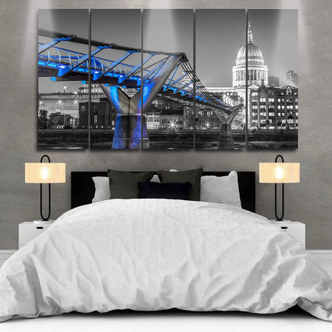 Modern bedroom featuring a multi-panel artwork of a city bridge in black and white with blue lighting accents.