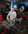 Mechanic working on car engine in a garage with cars on lifts