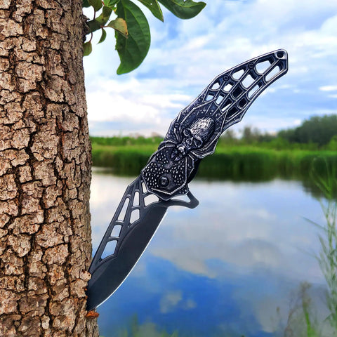 Pocket Folding Knife With 3D Embossed Skull Pattern, 3.6 Inch Razor Sharp 440 Stainless Steel Blade against tree outdoors
