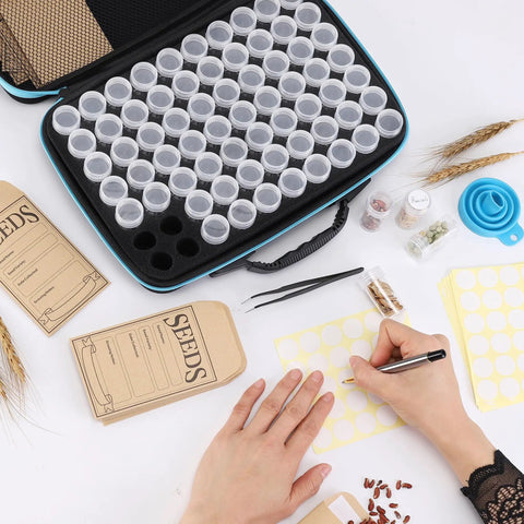 Seed Storage Organizer Kit With 70 Slots, 20 Seed Envelopes, label cards, funnel, tweezer on table with hands labeling