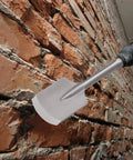 65A Shank Clay Spade Jackhammer Shovel Bit 4.3 by 16.5 Inch Alloy Steel Demolition Tool against brick wall