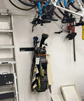 Garage storage with 2 Pack Golf Bag Wall Mount Rack holding golf bags and clubs, bikes overhead, and ladder beside