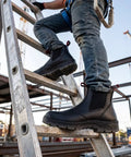 Person wearing Men Slip On Work Boots With Composite Toe climbing ladder at construction site