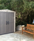 Factor 6x3 Outdoor Storage Shed Kit For Patio Furniture Lawn Tools Bikes Beach Gear Plus More Durable Resin Construction in Taupe and Brown next to bench and hammock