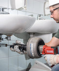 Professional Grade Pneumatic Air Powered 230V Drain Cleaning Tool in use under sink for stubborn residential clogs.