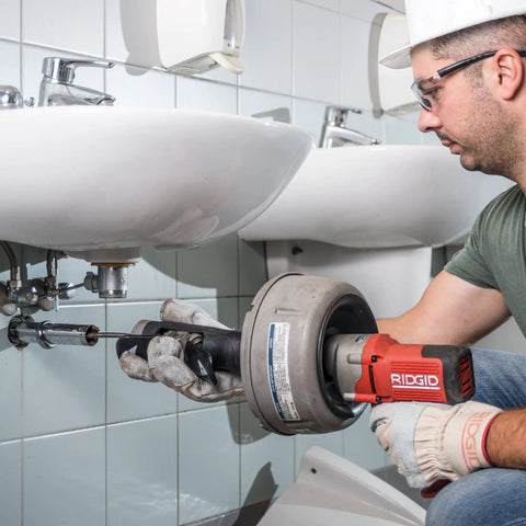 Professional Grade Pneumatic Air Powered 230V Drain Cleaning Tool in use under sink for stubborn residential clogs.