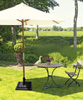 Garden view with a Beefed Up 30Lb Patio Market Umbrella Base With Cast Iron Tube Holder supporting an umbrella near a table.