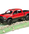 Red Ram 2500 Power Pickup Toy With Openable Doors And Tailgate on rocky path, 1:16 scale, durable build, spacious cab and cargo bed.