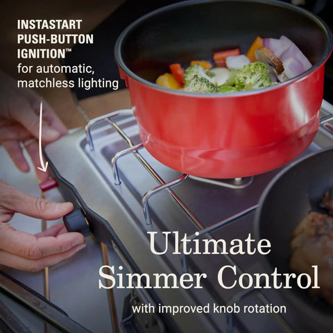 Two-Burner Propane Camp Stove With InstaStart Ignition And Wind Guards in use with pot on burner