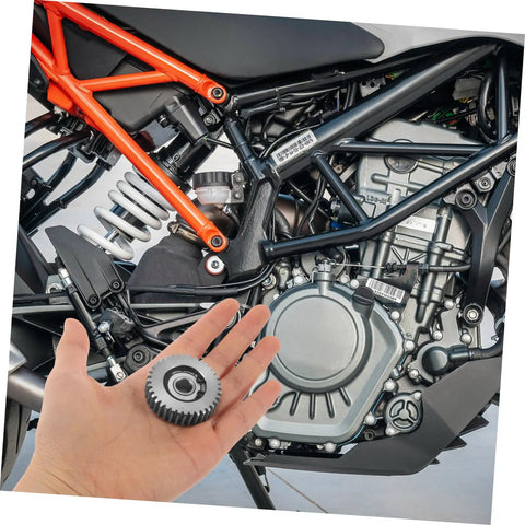 Hand holding gear above motorcycle engine illustrating Beefy 36 Tooth Motor Gear Set With Washers 3 Pcs Steel Gears for hubs