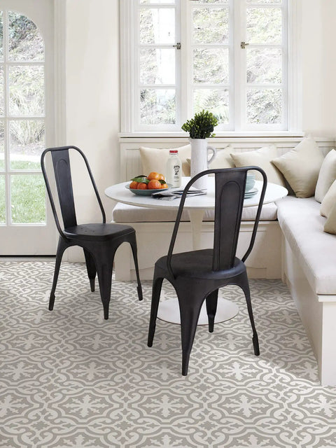 Dining area with Emilia Peel And Stick Floor Tiles in neutral grey and white farmhouse style under black chairs and white table.