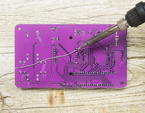 Noob Friendly Soldering Practice Kit for DIY Electronics Projects Learn to Solder with Detailed Circuit Schematics and Hands On STEM Education for Starters featuring purple circuit board with soldering iron tip in action.