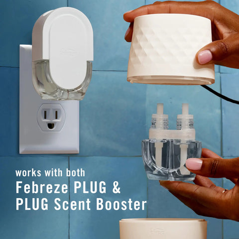 Hands holding Plug In Scent Booster Starter Kit With Ocean Refills, Black Oil Diffuser Air Freshener showing refills and device
