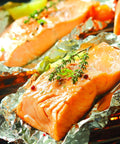Grilling salmon on Premium Aluminum Foil Pop Up Sheets in Dispenser, showing heavy duty, food safe use for cooking in kitchen essentials.