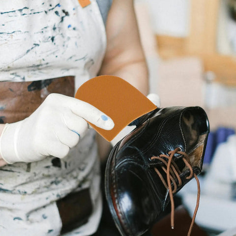 Self Adhesive Non Slip Heel Pads For Boots And Sneakers being applied to a black shoe for anti slip grip and comfort