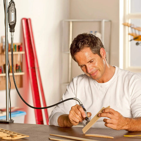 Person using Top Tier Variable Speed Rotary Tool Kit With Hella Steady Flex Shaft for woodworking detail on a wooden piece.