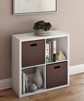 Open Back Four-Cube Storage Organizer In White with books and decor, sturdy shelving unit with bins, ideal for home or office space.