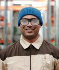 Heavy Duty Steampunk Welding Safety Glasses With Kick Ass Eye Protection Goggles worn by a smiling man in a blue beanie and work jacket.