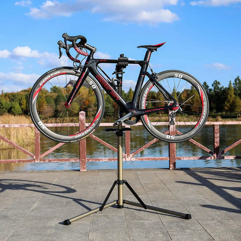 Adjustable Bike Work Stand With 360 Degree Rotatable Clamp And Height Adjustable Frame holding a bicycle outdoors.