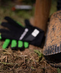 Beefy Post Hole Digger with serrated head for easy digging and no-slip H grip handles, next to gloves on grassy ground.