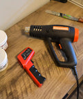 Beast Mode Heavy Duty Dual Temperature Heat Gun For Screen Printing Vinyl Shrink Wrap And Epoxy Resin Drying on a wooden table.