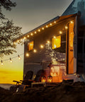 69 Foot G40 Globe Outdoor String Lights With 32 Edison Bulbs Plus 2 Spares illuminating a caravan at sunset, creating cozy ambiance.