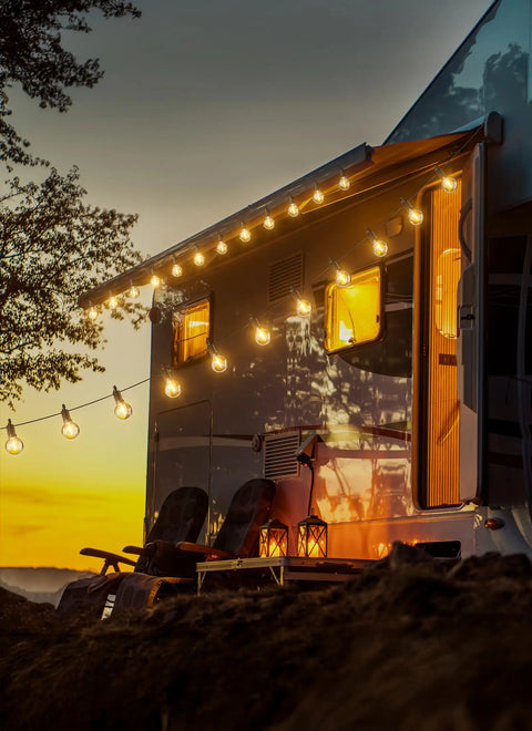 69 Foot G40 Globe Outdoor String Lights With 32 Edison Bulbs Plus 2 Spares illuminating a caravan at sunset, creating cozy ambiance.