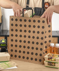 Person packing items into Polka Dot Kraft Paper Shopping Bags With Handles Large 15.9 By 9.8 By 17.3 Inch 100 Sustainable Takeout Bags