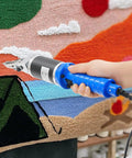 Top Shelf Electric Craft Scissors Engineered For Sharp Carpet Carving And Lightning Fast Tufting Trimming in use on a colorful rug.